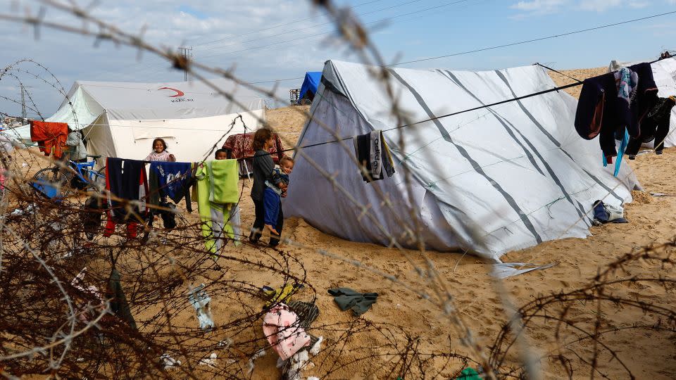 Children stand next to tents as displaced Palestinians, who fled their houses due to Israeli strikes, shelter in Rafah, in the southern Gaza Strip on January 26. - Ibraheem Abu Mustafa/Reuters