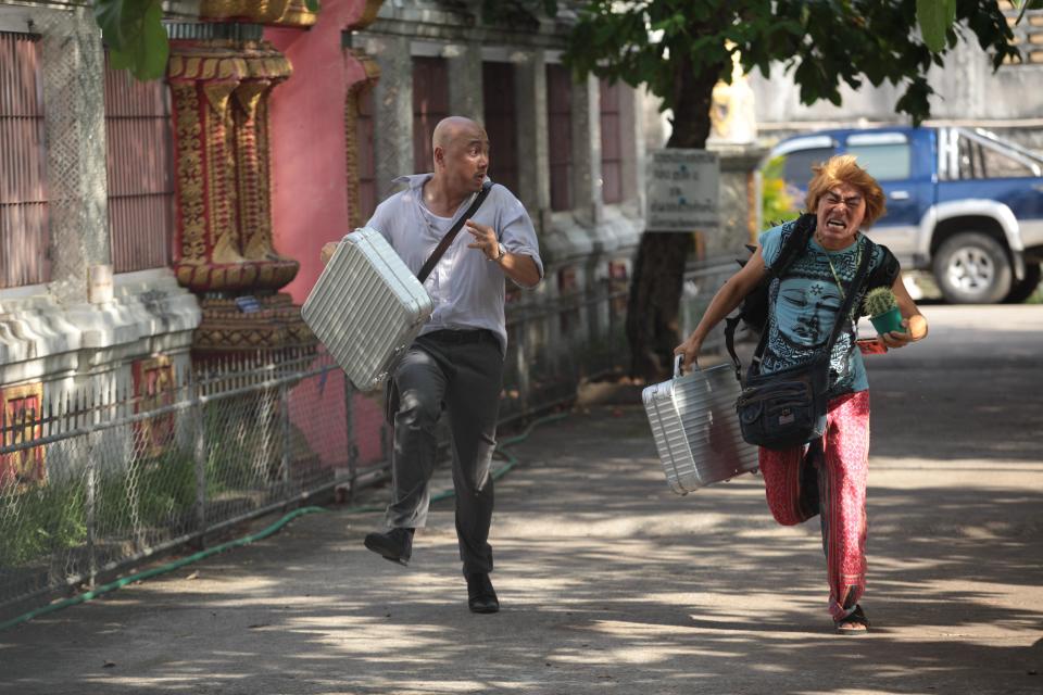 In this publicity image released by Pegasus Motion Pictures, Xu Zheng, left, and Wang Baoqiang run in a scene from "Lost in Thailand." Xu, the director, writer and star of China's biggest box-office hit, says "Lost in Thailand" succeeded by showing a rarely seen subject: modern Chinese life. The historical epic, fantasy, action and thriller genres have long filled China's domestic movie screens. But "Lost in Thailand" was a low-budget and light-hearted road-trip tale about an ambitious executive who goes to Thailand to get his boss' approval for a business deal. Along the way he's pursued by a rival co-worker and encounters a wacky tourist who helps him rethink his priorities. (AP Photo/Pegasus Motion Pictures)