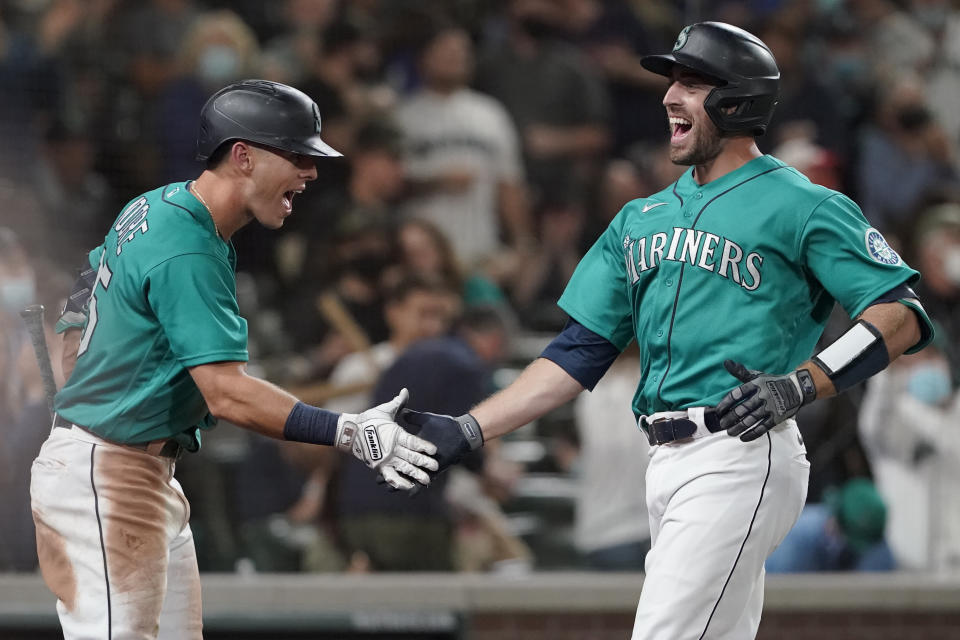 Seattle Mariners' Tom Murphy, right, is greeted by Dylan Moore after Murphy hit a solo home run during the sixth inning of the team's baseball game against the Arizona Diamondbacks, Friday, Sept. 10, 2021, in Seattle. The homer was Murphy's second in the game. (AP Photo/Ted S. Warren)