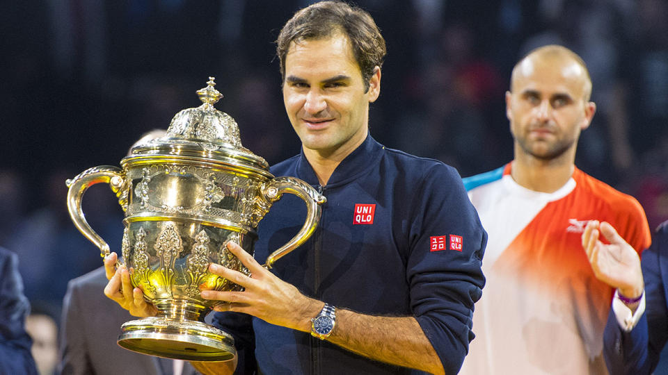 Roger Federer receives his winners trophy. (photo by David Emm/Action Plus via Getty Images)