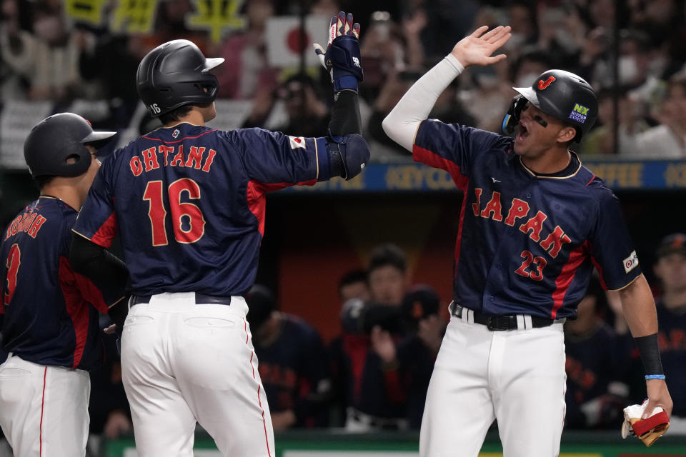 Shohei Ohtani of Japan, center, celebrates with teammate Lars Nootbaar after hitting home run against Australia during their Pool B game at the World Baseball Classic at the Tokyo Dome Sunday, March 12, 2023, in Tokyo. (AP Photo/Eugene Hoshiko)