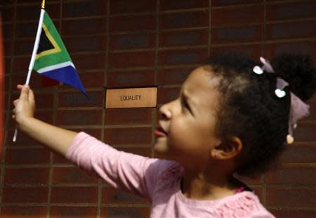 A girl waves a South African flag while visiting the house of Nelson Mandela in Soweto at the outskirts of Johannesburg December 7, 2013. REUTERS/Yannis Behrakis