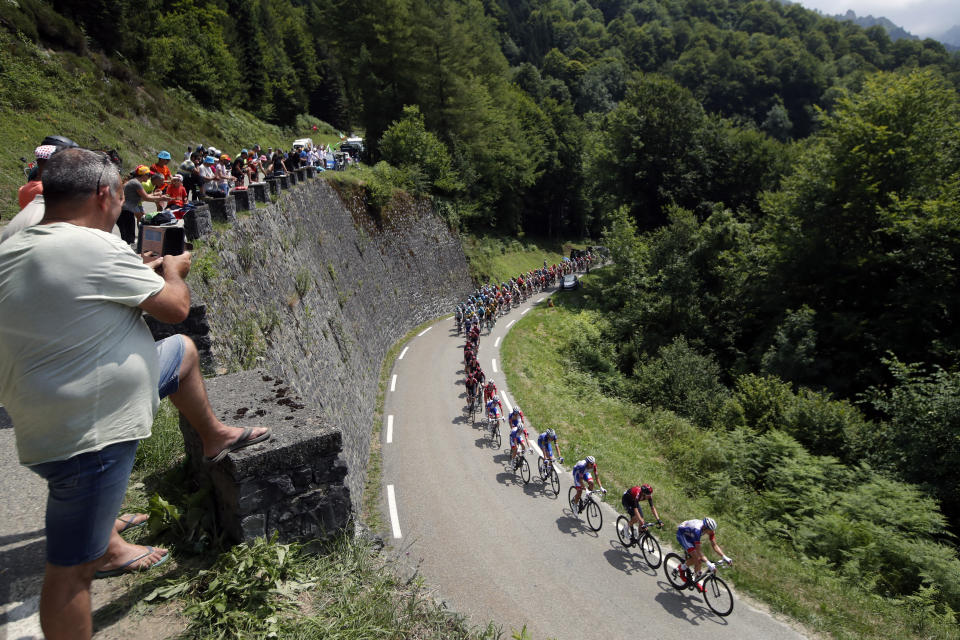 Spectators watch the pack as he rides during the fourteenth stage of the Tour de France cycling race over 117,5 kilometers (73 miles) with start in Tarbes and finish at the Tourmalet pass, France, Saturday, July 20, 2019. (AP Photo/ Christophe Ena)