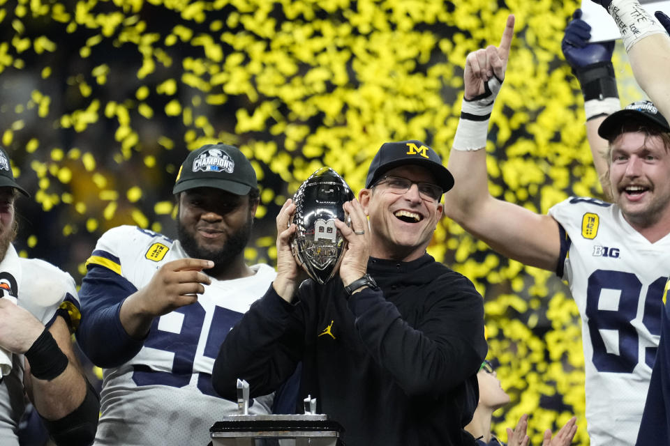 Michigan head coach Jim Harbaugh celebrates with his team after the Big Ten championship NCAA college football game against Iowa, Saturday, Dec. 4, 2021, in Indianapolis. Michigan won 42-3. (AP Photo/AJ Mast)