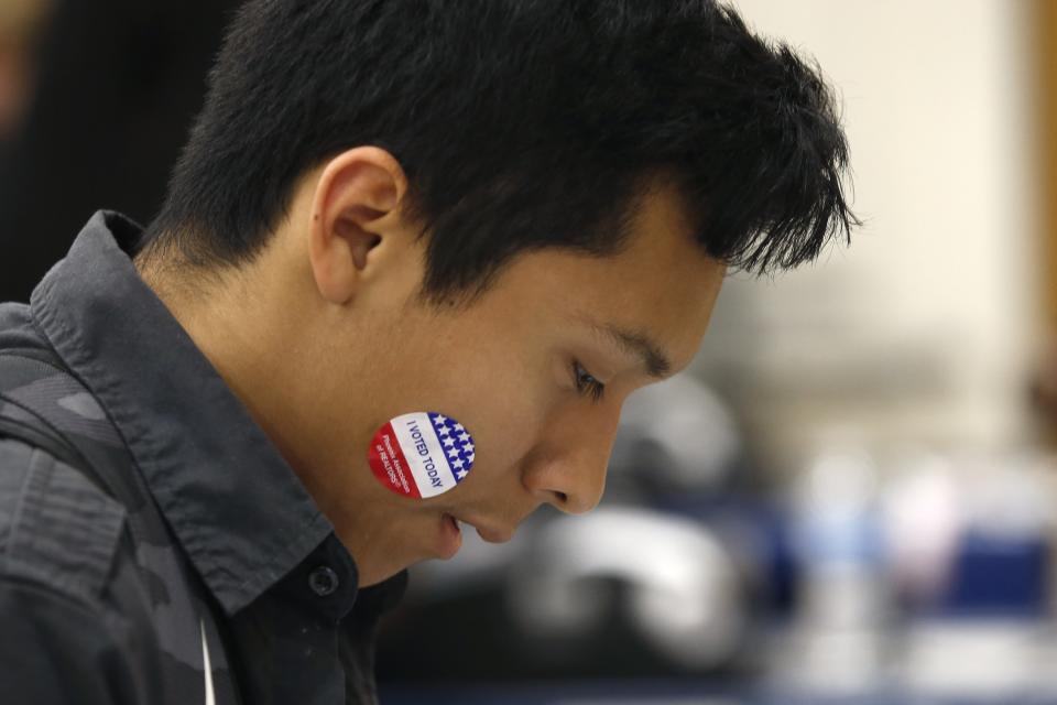 In this March 5, 2020, photo Angel Tapia displays his "I Voted Today" sticker as students participate in their own Democratic presidential preference election and voter registration drive at Maryvale High School in Phoenix. At the school hundreds of students who will turn 18 before Election Day were registered to vote. (AP Photo/Ross D. Franklin)