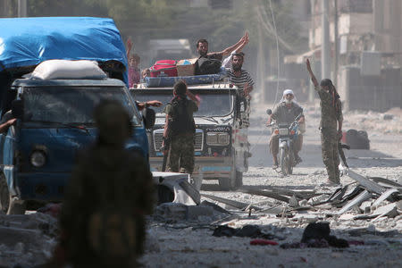 Syria Democratic Forces (SDF) fighters greet civilians who were evacuated by the SDF from an Islamic State-controlled neighbourhood of Manbij, in Aleppo Governorate, Syria, August 12, 2016. REUTERS/Rodi Said