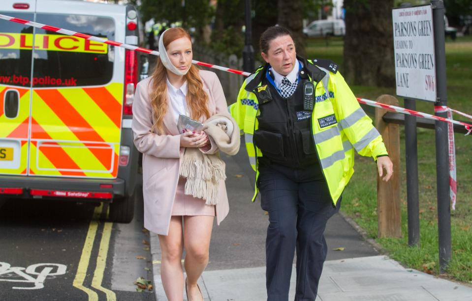 Police lead away an injured passenger in the aftermath of the attack (Rex)