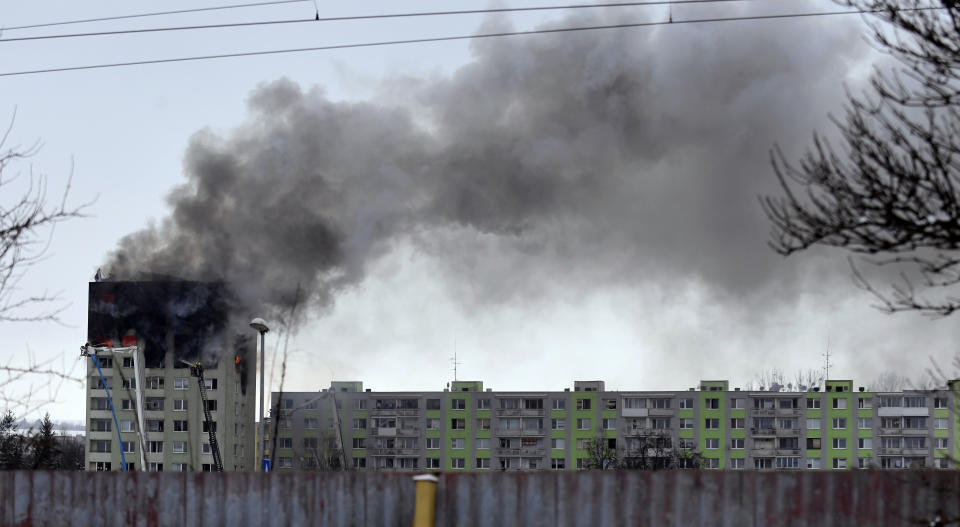 Smoke rise from a damaged 12-storey apartment block after a gas explosion in Presov, Slovakia, Friday, Dec. 6, 2019. Officials say a gas explosion in an apartment block in Slovakia has killed at least five people and others are trapped on the roof of the building. Firefighters say the explosion occurred in a 12-story building in the city of Presov shortly after noon on Friday. (Frantisek Ivan/TASR via AP)