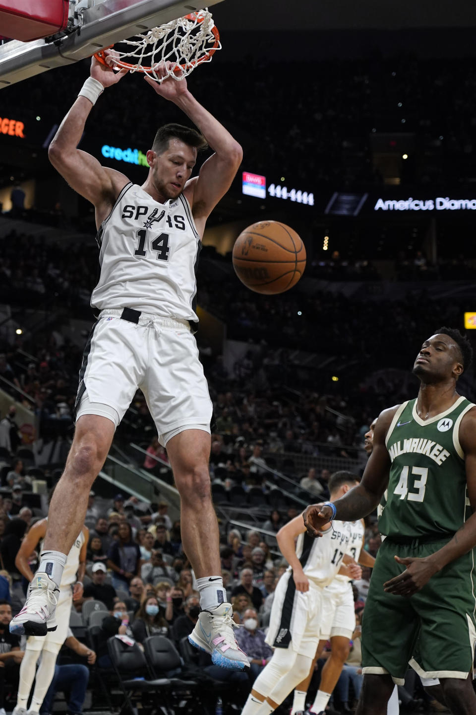 San Antonio Spurs' Drew Eubanks (14) dunks against Milwaukee Bucks' Thanasis Antetokounmpo (43) during the first half of an NBA basketball in San Antonio, Texas, Saturday, Oct. 23, 2021. (AP Photo/Chuck Burton)