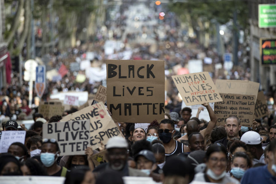 FILE - In this June 6, 2020, file photo, a protester looks up at a sign that reads "Black Lives Matter" in Marseille, southern France, during a protest against the recent death of George Floyd. Black Lives Matter has gone mainstream — and black activists are carefully assessing how they should respond. (AP Photo/Daniel Cole, File)