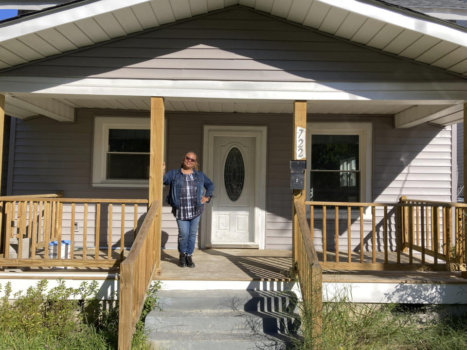 Karen Speights stands on the porch of her 1920s craftsman house in Norfolk, Va., Friday Oct. 7, 2022. A contractor had replaced the historic home’s original pine floor after a flood and installed laminate flooring. (AP Photo/Ben Finley)
