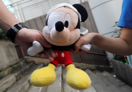 Secondary schools hold a stuffed doll of Mickey Mouse with its eye covered as they form a human during a protest against the police brutality, after clash with protesters at Wan Chai district in Hong Kong