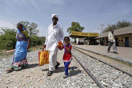 People cross a railway track at Vadnagar railway station in Gujarat March 26, 2014. REUTERS/Amit Dave