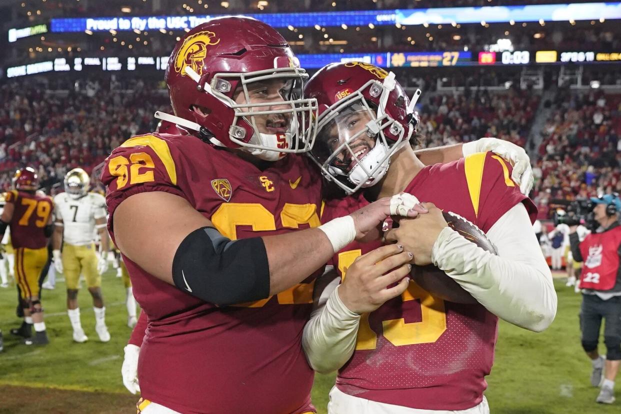 USC quarterback Caleb Williams gets a hug from offensive lineman Brett Neilon.