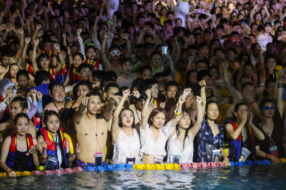 This photo, taken on August 15, 2020 shows people watching a performance as they cool off in a swimming pool in Wuhan in China's central Hubei province.<span class="copyright">Photo by STR/AFP via Getty Images</span>