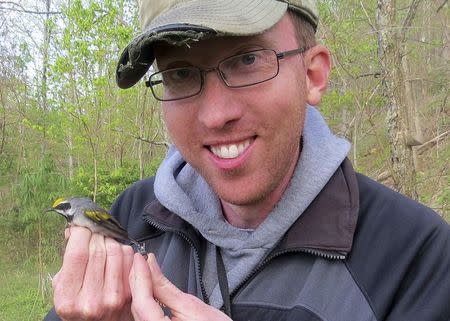 Henry Streby holds a male golden-winged warbler and the geolocator that the bird carried for more than twelve months including during the evacuation migration, in the Cumberland Mountains of Tennessee, in this undated handout photo provided by Gunnar Kramer. Scientists said on December 18, 2014 a population of this bird fled its nesting grounds in Tennessee up to two days before the arrival of a fierce storm system that unleashed 84 tornadoes in southern U.S. states in April, apparently alerted to the danger by sounds at frequencies below the range of human hearing. Mandatory Credit REUTERS/Gunnar Kramer