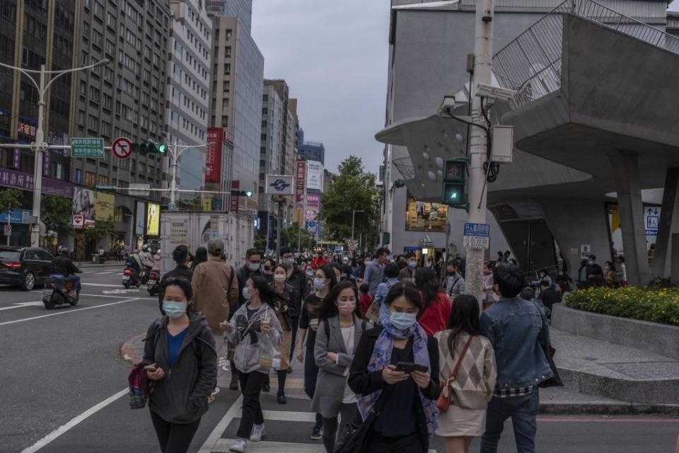 Pedestrians wearing protective masks cross a street at a shopping district in Taipei, Taiwan, on Saturday, April 16, 2022.<span class="copyright">Lam Yik Fei/Bloomberg via Getty Images</span>