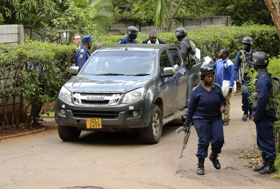 Armed police officers outside the residence of Evan Mawarire, an activist and pastor who helped mobilize people to protest against the hike in fuel prices, following his arrest in Harare, Zimbabwe, Wednesday, Jan. 16, 2019. Mawarire was arrested Wednesday for allegedly inciting violence in the protests against the government's increase in fuel prices. (AP Photo/Tsvangirayi Mukwazhi)