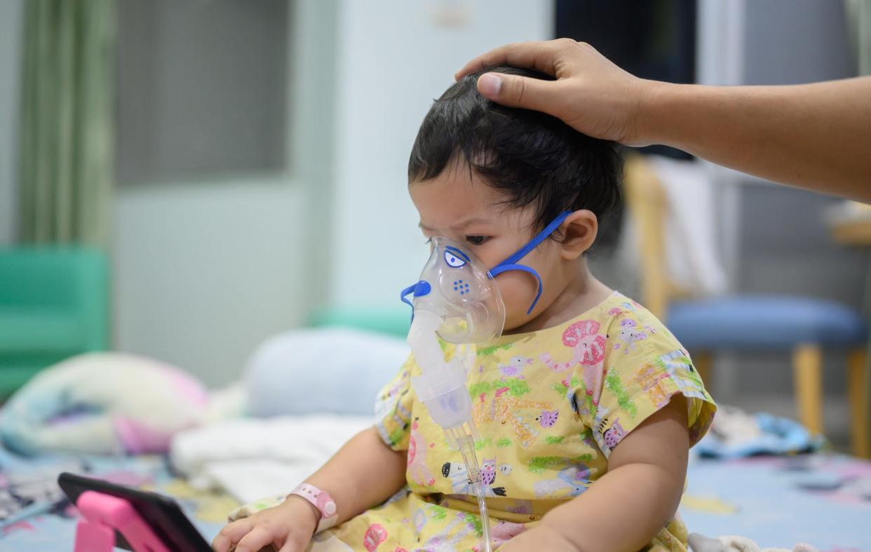 A baby with respiratory syncytial virus is given an inhaler treatment at a hospital.