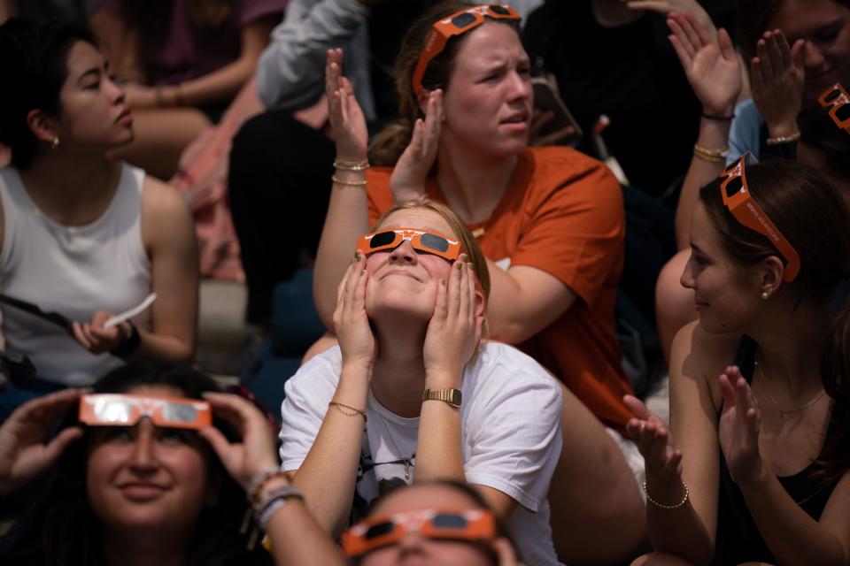 Students take in the eclipse while listening to Mariachi Paredes de Tejastitlán at the University of Texas in Austin, Tex., Monday, April 8, 2024.