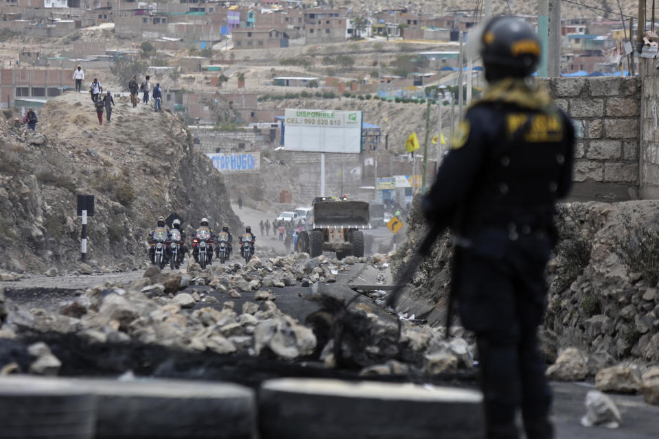 Police arrive to clear debris from a highway, placed by supporters of ousted Peruvian President Pedro Castillo protesting his detention in Arequipa, Peru, Thursday, Dec. 15, 2022. Peru's new government declared a 30-day national emergency on Wednesday amid violent protests following Castillo's ouster, suspending the rights of "personal security and freedom" across the Andean nation. (AP Photo/Fredy Salcedo)