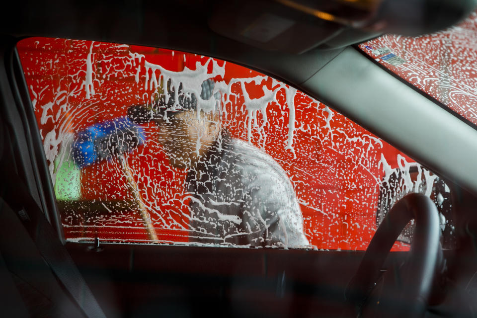 El propietario de Vivas Hand Car Wash, Telesforo Vivas, de Sanford, Carolina del Norte, que lleva cinco años con el negocio, lava la ventana de un auto en Burlington, Carolina del Norte, el miércoles 11 de marzo de 2020. Su lavadero está junto a otros negocios de propiedad latina. (AP Foto/Jacquelyn Martin)