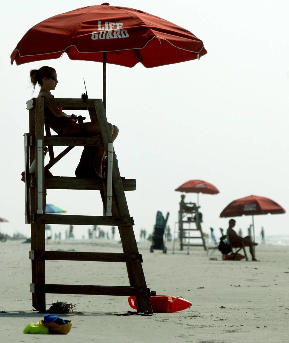 Shore Beach Service lifeguards, including Emily Savage, foreground, man their stations at Coligny Beach on Friday. Savage, a college student from Canada, is spending the summer working as a lifeguard on Hilton Head Island. “I love it,” she says, “it’s one of the best jobs I’ve ever had.”