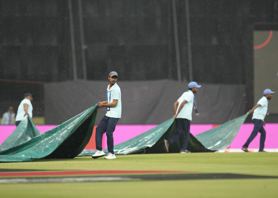 Grounds men cover the field as rain disrupts the the ICC Men's Cricket World Cup match between Australia and Sri Lanka in Lucknow, India, Monday, Oct. 16, 2023. (AP Photo/Aijaz Rahi)