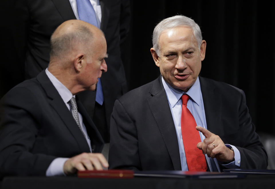 California Gov. Jerry Brown, left, and Israeli Prime Minister Benjamin Netanyahu, right, talk after signing an agreement to expand cooperation at the Computer History Museum Wednesday, March 5, 2014, in Mountain View, Calif. Netanyahu is visiting California, trading a focus on the geopolitics of the Middle East for a Hollywood screening and visits with Silicon Valley tech entrepreneurs.(AP Photo/Eric Risberg)