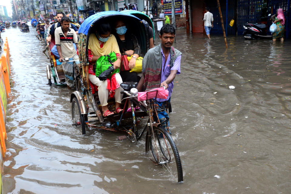 Vehicles and pedestrians slog through floodwaters in Dhaka streets in Bangladesh last October. Though Bangladesh has contributed relatively little to global emissions compared with the U.S., it faces some of the most dire consequences of global warming. (Photo: NurPhoto via Getty Images)