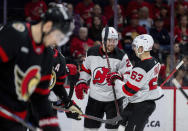 New Jersey Devils defenseman Brendan Smith (2) and teammate Jesper Bratt (63) celebrate after a goal scored by Devils center Nico Hischier (not shown) against the Ottawa Senators during second-period NHL hockey game action in Ottawa, Ontario, Saturday, April 6, 2024. (Spencer Colby/The Canadian Press via AP)