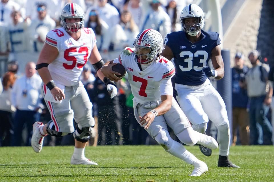 Oct 29, 2022; University Park, Pennsylvania, USA; Ohio State Buckeyes quarterback C.J. Stroud (7) scrambles away from Penn State Nittany Lions defensive end Dani Dennis-Sutton (33) during the first half of the NCAA Division I football game at Beaver Stadium. Mandatory Credit: Adam Cairns-The Columbus Dispatch