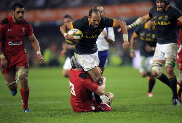 South African scrumhalf Fourie Du preez (C) is tackled by Wales centre Jon Davies (down) during the Rugby test match at Kings Stadium on June 14, 2014 in Durban, South Africa