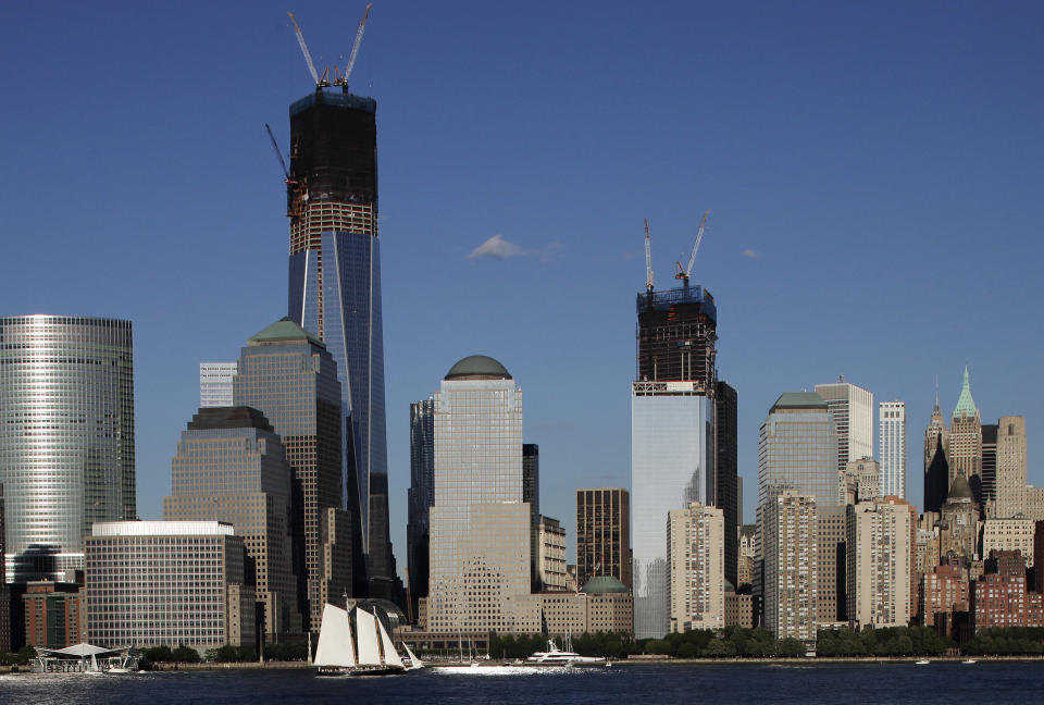 In a photo made Saturday, June 23, 2012, construction cranes perch on top of One World Trade Center, left, and Four World Trade Center in New York. Four WTC will have its topping out ceremony, in which the last steel beam is put in place, Monday, June 25.  (AP Photo/Mark Lennihan)