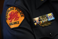 The Waterloo Police Dept. patch is seen on the arm of Chief Joel Fitzgerald as he speaks during an interview with The Associated Press, Tuesday, Sept. 7, 2021, in Waterloo, Iowa. Fitzgerald, the first Black police chief in Waterloo, is facing intense opposition from some current and former officers as he works with city leaders to reform the department, including the removal of its longtime insignia that resembles a Ku Klux Klan dragon. (AP Photo/Charlie Neibergall)