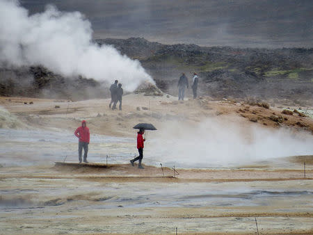 People look on as fumes come out of the ground near Reykjahlid, Iceland, September 19, 2015. Picture taken September 19, 2015. REUTERS/Lefteris Karagiannopoulos