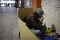 In this Tuesday, Jan. 7, 2020, photo, a homeless man eats his late dinner in a cardboard box at Shinjuku Station, in Tokyo. The dozens of homeless people sleeping rough in shuttered Tokyo subway stations worry that with Japan's image at stake authorities will force them to move ahead of the Olympics. (AP Photo/Jae C. Hong)