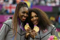 <p>Gold medalists Serena Williams of the United States and Venus Williams of the United States celebrate during the medal ceremony for the Women’s Doubles Tennis on Day 9 of the London 2012 Olympic Games at the All England Lawn Tennis and Croquet Club on August 5, 2012 in London, England. (Photo by Clive Brunskill/Getty Images) </p>