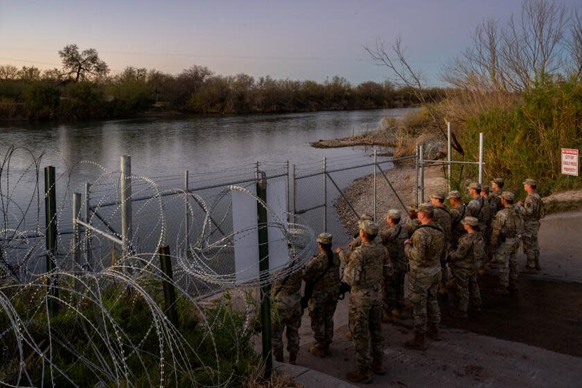 National Guard soldiers stand guard on the banks of the Rio Grande river at Shelby Park in Eagle Pass, Texas.