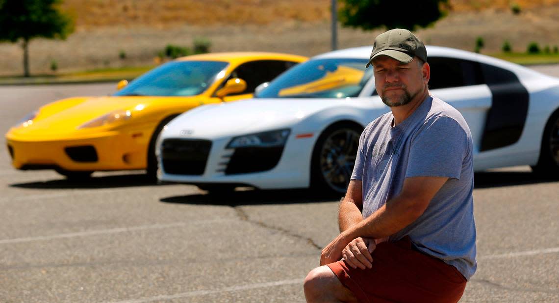 Steve Zetz of Benton City claims he and others were scammed by a business they paid to customize their vehicles. Behind Zetz are a friend’s yellow 1999 Ferrari 360 Modena and a 2020 Audi r8. Bob Brawdy/bbrawdy@tricityherald.com
