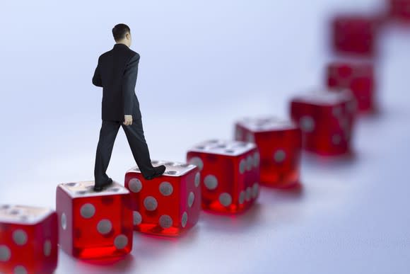 Man walking along a path of red dice