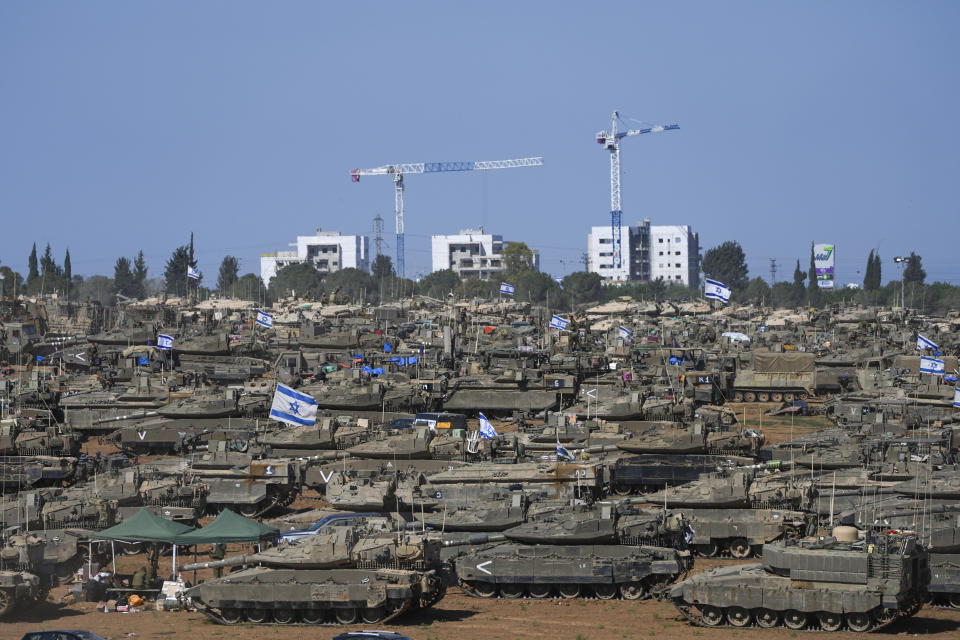 Israeli soldiers work on armored military vehicles at a staging ground near the Israeli-Gaza border, in southern Israel, Wednesday, May 8, 2024. (AP Photo/Tsafrir Abayov)