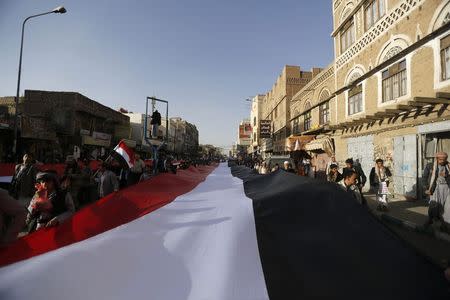 Pro-Houthi protesters carry the national flag as they demonstrate to commemorate the fourth anniversary of the uprising that toppled former President Ali Abdullah Saleh in Sanaa February 11, 2015. REUTERS/Khaled Abdullah