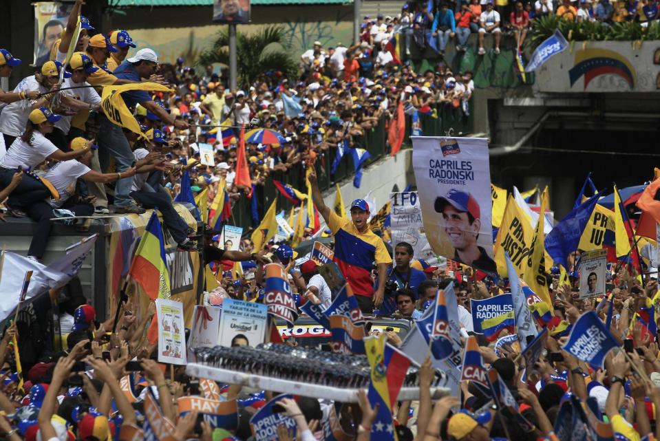 CORRECTS BYLINE - Opposition presidential candidate Henrique Capriles, center, gestures to supporters during a campaign rally in Caracas, Venezuela, Sunday, Sept. 30, 2012. Presidential elections in Venezuela are scheduled for Oct. 7. (AP Photo/Fernando LLano)