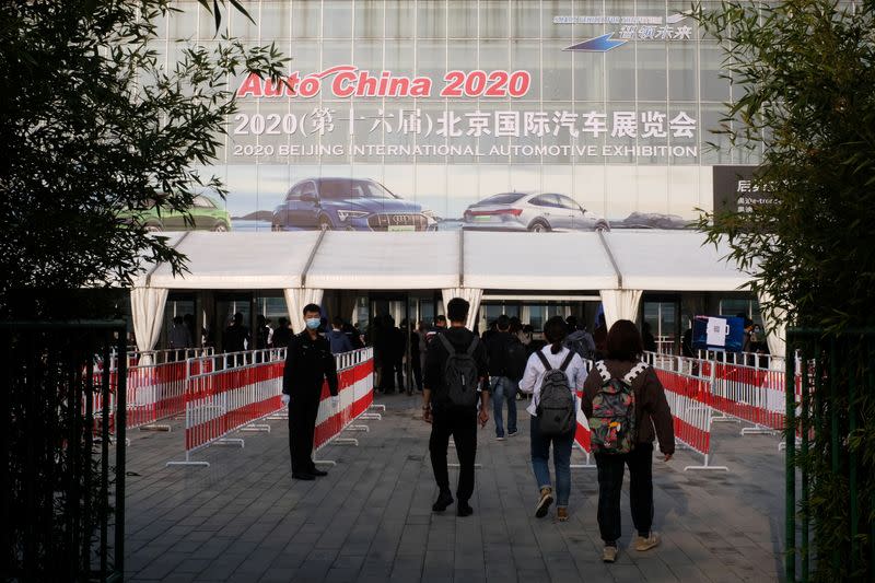 People wearing face masks following the coronavirus disease (COVID-19) outbreak enter the venue of the Beijing International Automotive Exhibition, or Auto China show, in Beijing