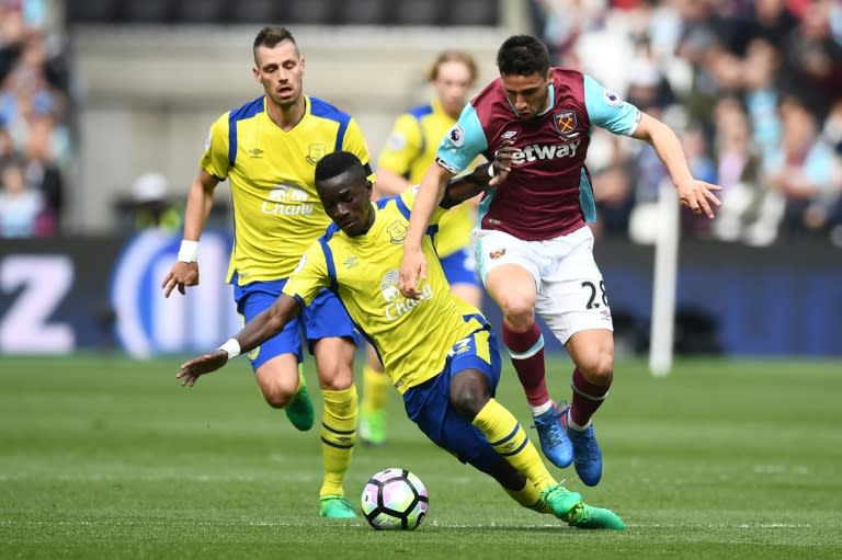 Everton's Idrissa Gueye (L) tackles West Ham United's Jonathan Calleri during their English Premier League football match at The London Stadium on April 22, 2017