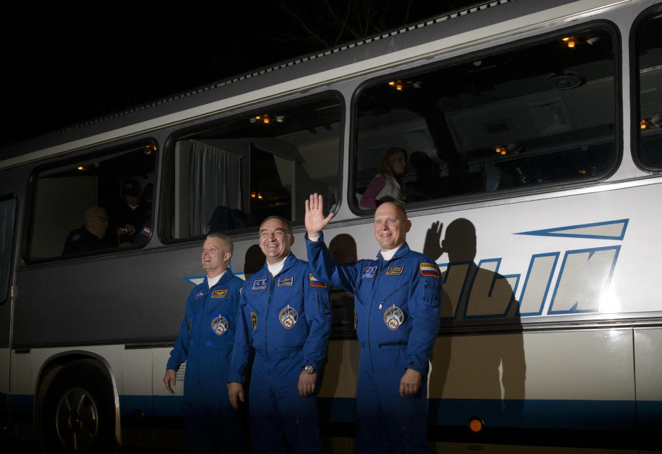 In this image released by NASA, from left, Expedition 39 flight engineer Steven Swanson of NASA, Soyuz commander Aleksander Skvortsov, of the Russian Federal Space Agency (Roscosmos), and flight engineer Oleg Artemyev of Roscosmos, wave as they depart the Cosmonaut Hotel Tuesday, March 25, 2014, in Baikonur, Kazakhstan. The mission is set to launch March 26 from the Baikonur Cosmodrome. (AP Photo/NASA, Joel Kowsky) MANDATORY CREDIT