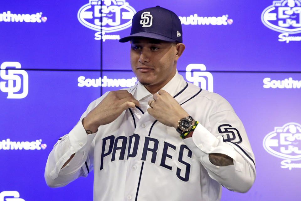 Manny Machado se coloca su franela al ser presentado como nuevo jugador de los Padres de San Diego, el viernes 22 de febrero de 2019 en Peoria, Arizona. (AP Foto/Charlie Riedel)