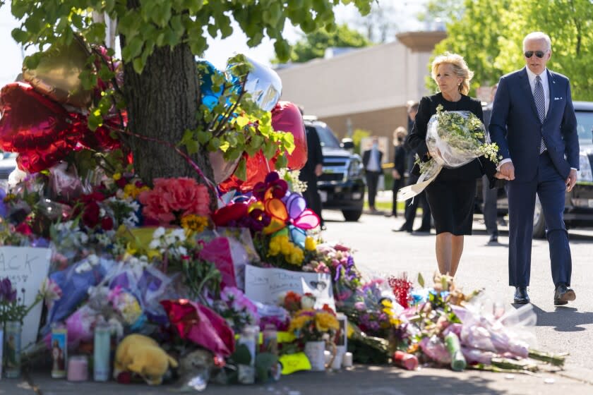 El presidente Joe Biden y la primera dama Jill Biden presentan sus respetos a las víctimas del tiroteo del sábado en un memorial frente al mercado TOPS en Buffalo, Nueva York, el martes 17 de mayo de 2022. (Foto AP/Andrew Harnik)