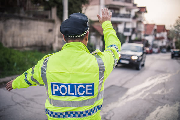 Un policía cargó a un anciano para ayudarlo a cruzar la calle. Foto: South_agency / Getty Images.